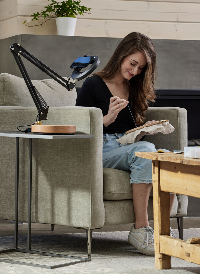 Black adjustable Canvas LED desk lamp with wooden base set up to take video of a creator